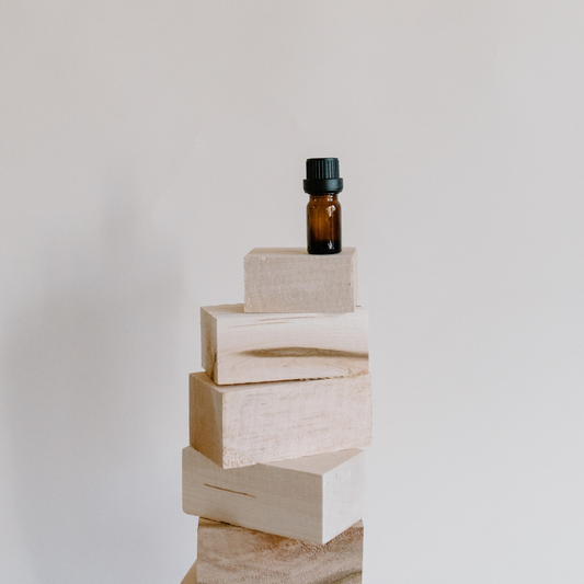 Essential Oil bottle sitting on wooden blocks.